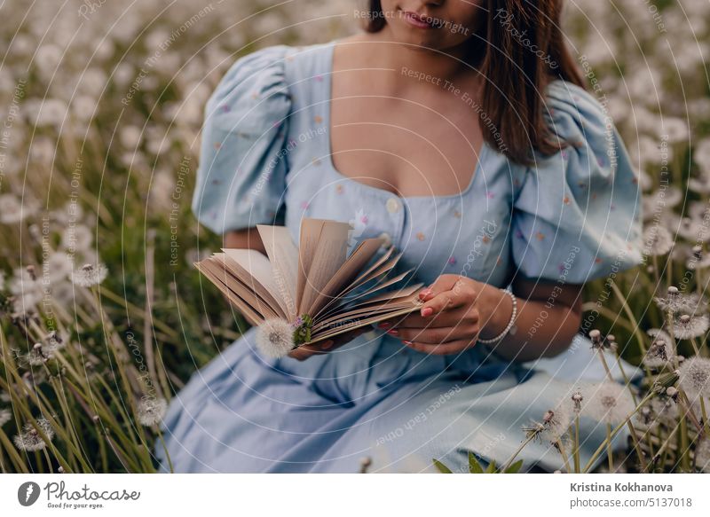 Woman flips through pages of paper book. Lady in retro or vintage dress reading interesting novel while sitting on nature. Atmospheric scene. Education, hobby, entertainment concept.