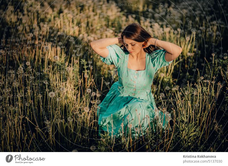 Portrait of young rural elegant woman posing on nature background. Sexy languid lady touching hair, enjoying summertime, sun rays. Vintage styled dress. vintage