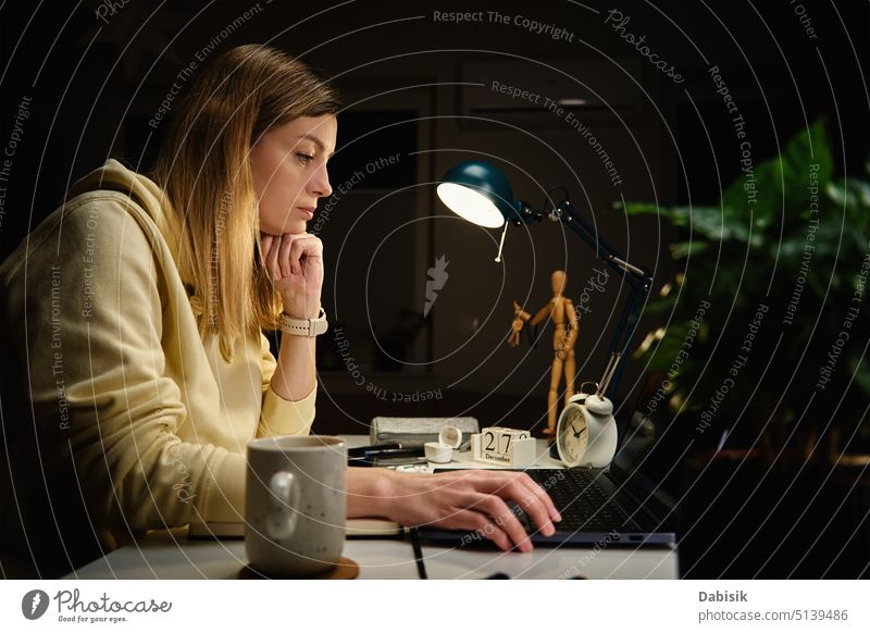 Woman works at home office at night, using laptop woman tired stress late work over work burnout bored exgausted overworked freelance computer room time
