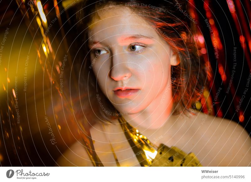 Young party girl looks quite lost amid glitter and tinsel Girl celebrations Firm Party Disco Glitter Glimmer Gold shine Decoration Wearing makeup styled Doomed