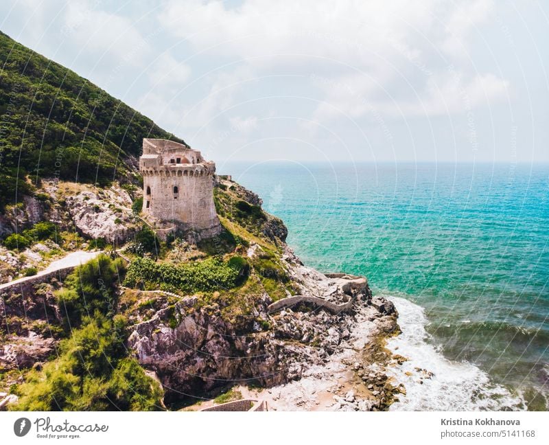 Beautiful scene, old building. Ancient defense tower on mountain in the Mediterranean sea. Paola tower is placed on Circeo promontory of Sabaudia, Italy. View from drone, aerial.