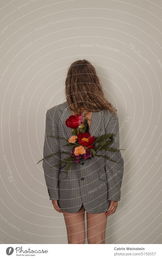 A female person with long hair photographed from behind. She is wearing a jacket upside down with flowers inside. Bouquet Woman long hairs Full-length