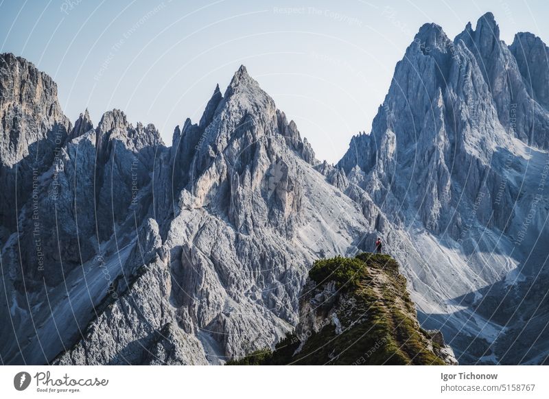 Man hiker standing and admiring stunning beauty of impressive jagged peaks of Cadini di misurina mountain group in Dolomites, Italy, part of Tre Cime di Levaredo national park