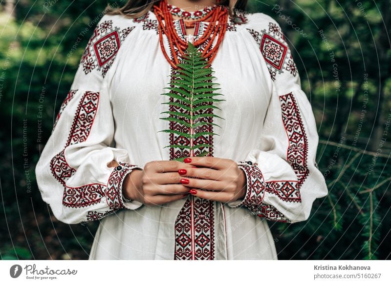 Authentic woman in traditional ukrainian costume with fern in forest. attractive beautiful beauty clothes confident culture dance dress embroidered shirt