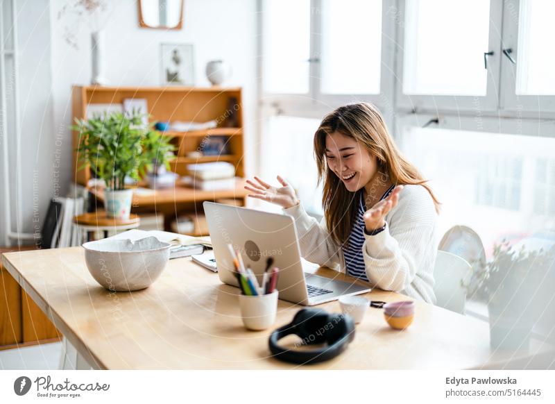 Young woman sitting at desk working on laptop real people millennials student indoors loft window natural girl adult one attractive successful confident person