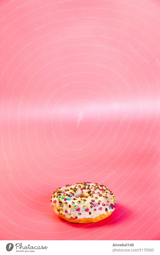 Sweet donuts stacked in a stack on a pink background. Copy space, various glaze and sprinkels chocolate chip, snack fast food sweets concept glazed sugar