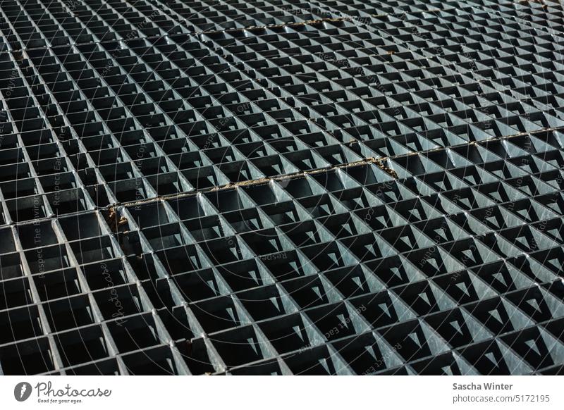 Image-filling shot of a heavy-duty metal grating as a drivable cover of a pouring trough reflection metallic architecture steel grating strong gratings factory