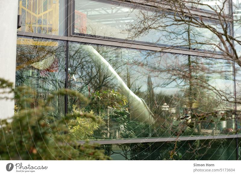 Slide behind glass pane Leisure and hobbies recreational activity Playground Playing Green plants Skid reflection Reflection Trip free time entry Glas facade