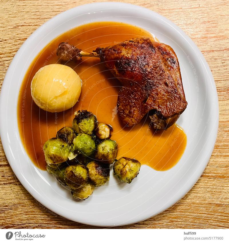 Duck leg, dumpling and roasted Brussels sprouts with sauce on white plate gravy dumpling Roasted Sauces Dumpling Rustic Meat Eating Dinner Portion Plate Meal