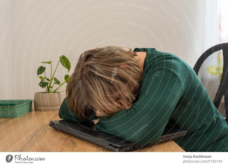 A woman is sleeping on a laptop at a desk. Woman Sleep Stress Exhaustion home office Desk Workplace Online labour Technology job Modern at home burnout tired