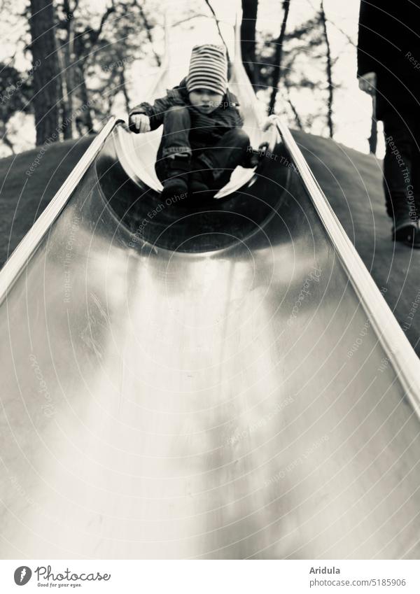 Child sliding very carefully down the very long slide in b&w Boy (child) Playground Slide Playing Exterior shot Infancy Skid Movement Man Father dad Fear