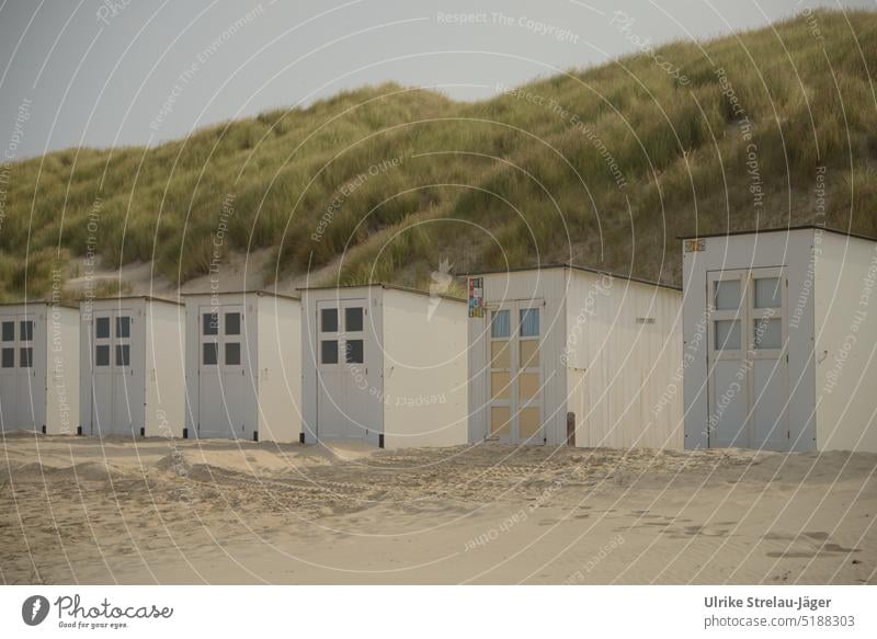 Beach huts white and alternatively with yellow and light blue door on dunes beach hut Wooden hut white beach hut yellow wooden door Wooden door Sandy beach
