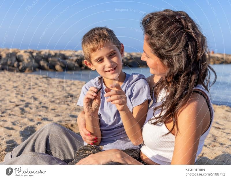 Happy Mother and son playing on beach in a sunny day at sundet. Family together sea sunset outdoor Toddler kid boy family Mom fun smile sand spring summer