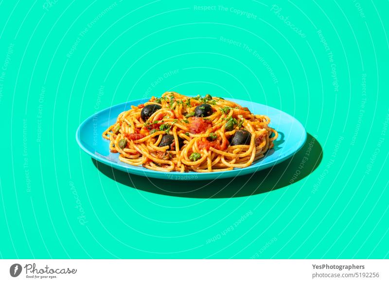 Spaghetti puttanesca plate in bright light, minimalist on a green background blue capers carbs close-up color cooked copy space cuisine cut out delicious diet