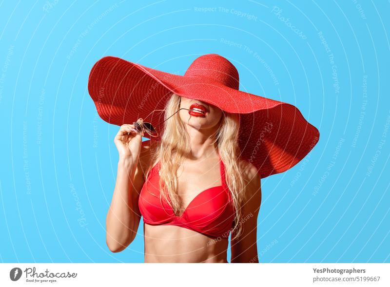 Summer portrait of a woman wearing a red swimsuit and big summer hat, isolated on a blue background beach beauty bikini blonde body bra brim chic cool design