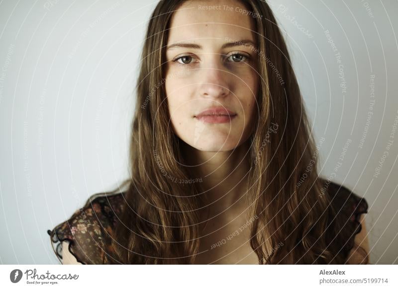 Close portrait of young brunette woman in a dark summer dress in front of a white wall Face Face of a woman Woman Young woman pretty daintily Brunette Bright