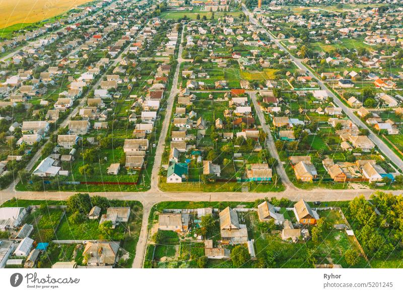 Aerial View Of Town Village Cityscape Skyline In Summer Day. Residential District, Houses And Garden Beds In Bird's-eye View. village aerial aerial view