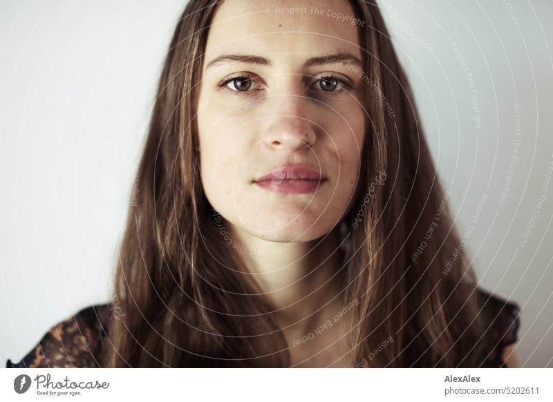 Close portrait of young brunette woman in a dark summer dress in front of a white wall Face Face of a woman Woman Young woman pretty daintily Brunette Bright