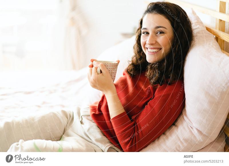 young woman in red bra reading problems in sex book while lying in bed, Stock image