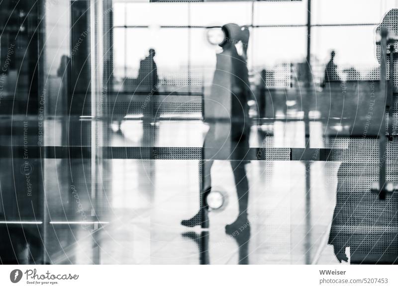 Several travelers with and without luggage reflected in the glass facade of the airport Glass reflection Mirror image mirror Luggage air passengers Airport