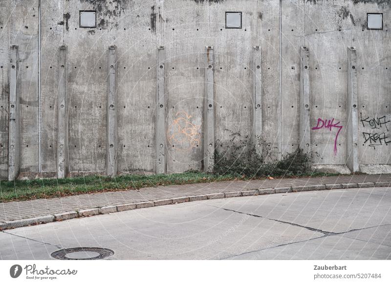 Street of concrete slabs swings in an elegant arc in front of concrete wall with supporting pillars, urban arrangement in light gray Arch Curve Concrete