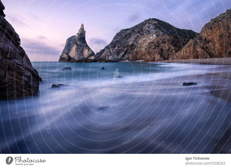 Epic Ursa Beach, Sintra, Portugal. Beach with waves and jugged rock peak in evening soft sunset light. Atlantic Ocean coast landscape ursa beach portugal