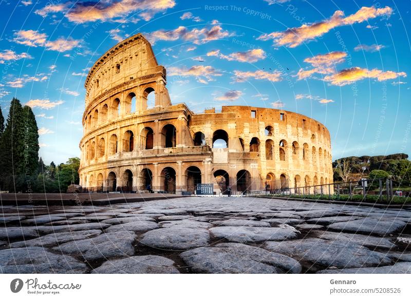The Colosseum at sunset in Rome, Italy. Low angle view of the main facade of the Colosseum and, in the foreground, the ancient paving in polished stone slabs.