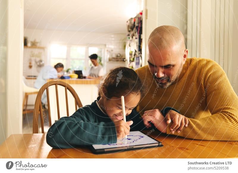 Multiracial father and son with Down syndrome using digital tablet doing homework family lifestyle draw multiracial down syndrome man boy fathers day child