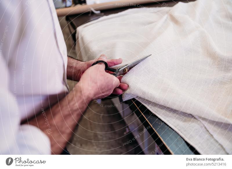 senior man working in atelier cutting curtains. Small business small business shop fabrics ironing job entrepreneur crafts denim profession self employed
