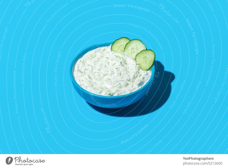Bowl with tzatziki sauce isolated on a blue background above appetizer bowl breakfast bright cacik color copy space cream cucumber cuisine cut out dairy
