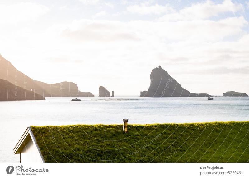 View of offshore island with green roof of house in sunlight Street rocky Bad weather Environment Hill Rock highlands Rural harmony Weather Picturesque