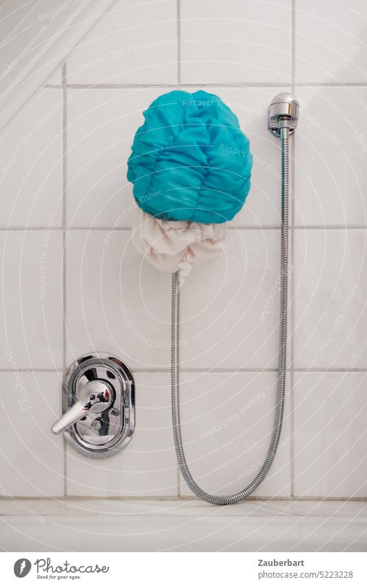 Blue shower cap, hose in arch and faucet in chrome in front of white tiles Shower cap take a shower Hose Fittings mixer tap Chrome Arch Hang White bathroom