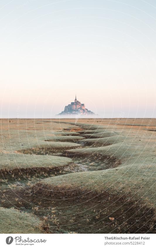 Dry riverbed in front of Mont Saint Michel in morning mist Meadow Blue sky Grass Landscape mont saint michel Mont St. Michel France Landmark Tourism