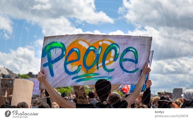 Man holds a banner with the inscription " Peace " in the air peace Word transparent Peace Wish Anti-war demonstration Ukraine Ukraine war peace demo Humanity
