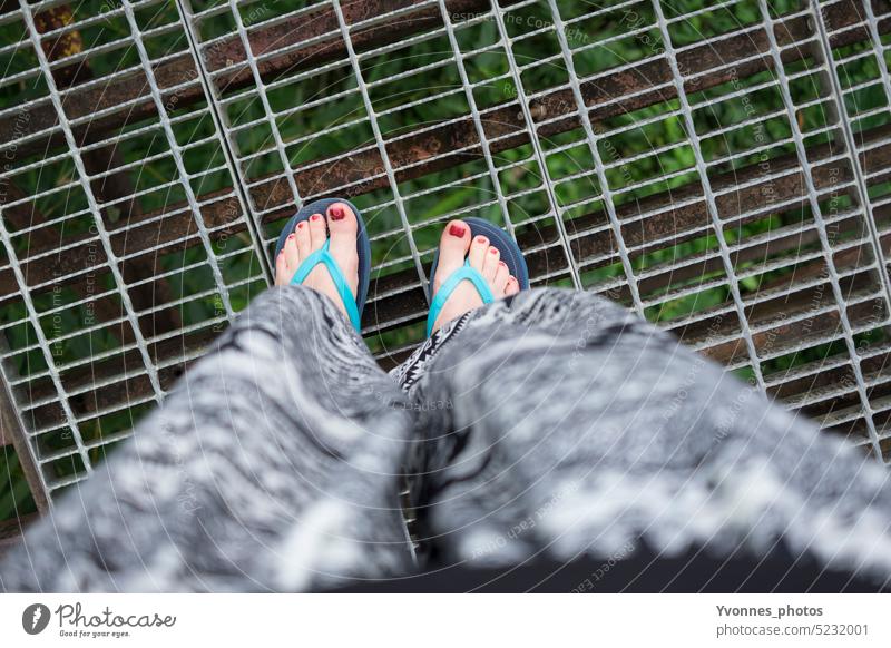 Woman with flip flops on a bridge in the jungle - a Royalty Free