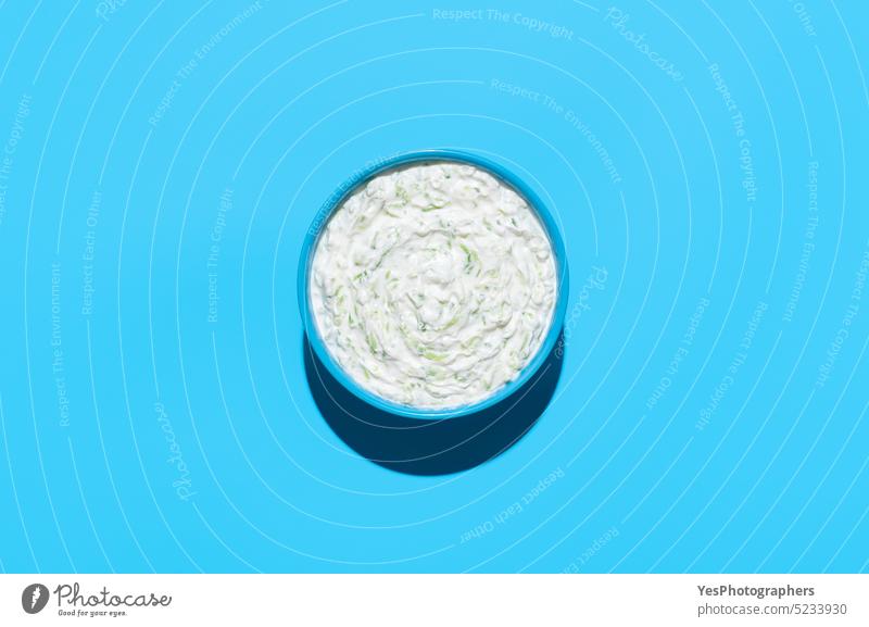 Tzatziki sauce bowl top view on a blue background above appetizer breakfast bright cacik color copy space cream cucumber cuisine cut out dairy delicious design