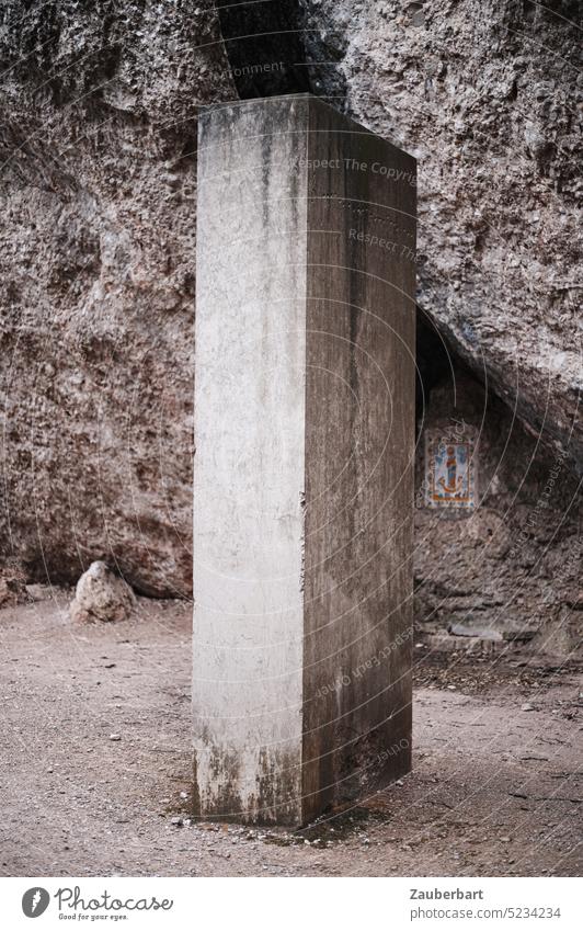 Strange concrete column or concrete block stands on the path in front of gray rocks Concrete column Concrete cuboid Column Cuboid Gray off Stand Puzzle puzzling