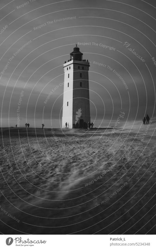 A lighthouse in a sand dune surrounded by people. Lighthouse sand dunes Black & white photo White sandy Sand Mystic Timeless Loneliness Adventure Denmark Wind