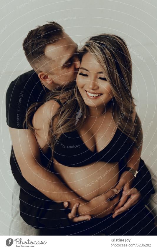 Husband and wife hugging on a mountain road stock photo - OFFSET