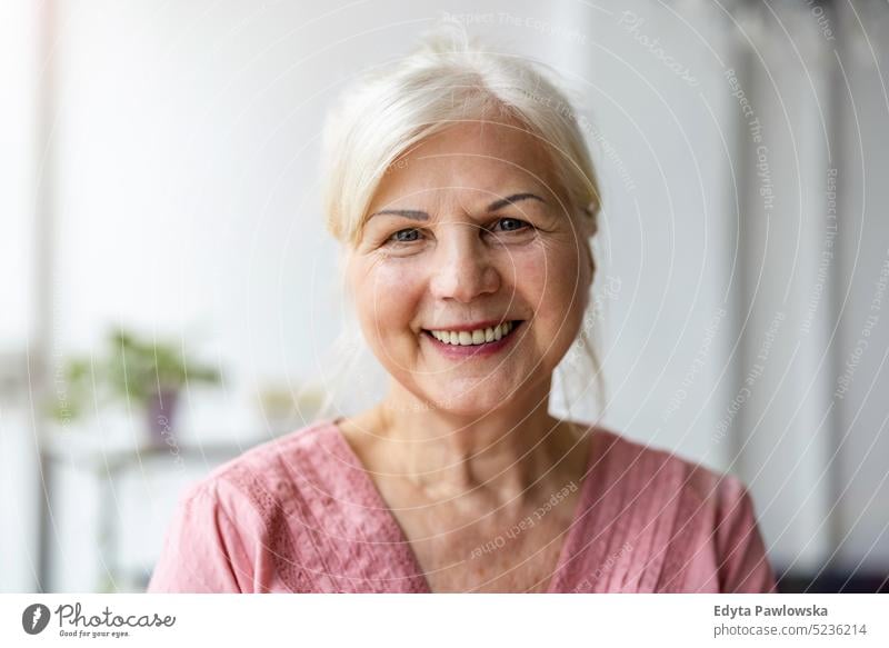 Portrait of smiling senior woman looking at camera real people indoors loft window home mature adult one person attractive successful confident beautiful female