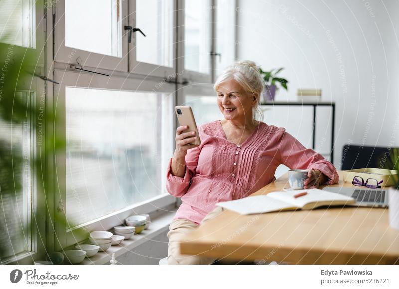 Senior man looking out of window in a loft flat stock photo