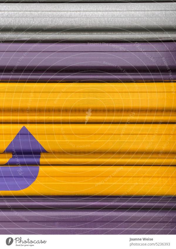 Purple and yellow garage door with purple arrow pointing up Yellow colourful colours Garage door garage entrance Pattern lines Exterior shot directions