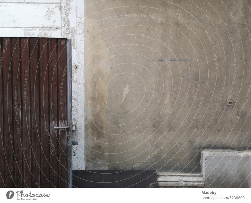 Old brown wooden door and washed out facade in beige and natural colors in a courtyard in the city center of Lage near Detmold in East Westphalia-Lippe German