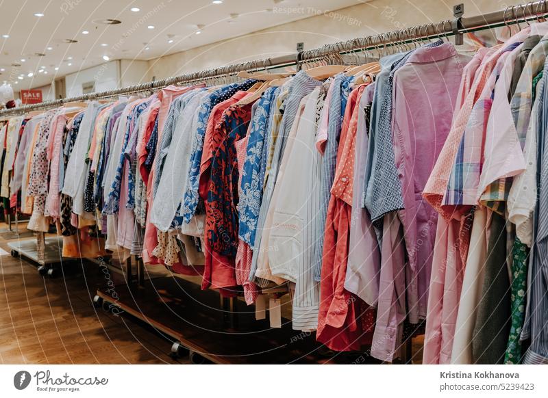 Women clothing hang on hangers inside of a shopping mall. Elegant clothes. Women  fashion industry. Classic design. Merchandise in a shop Stock Photo