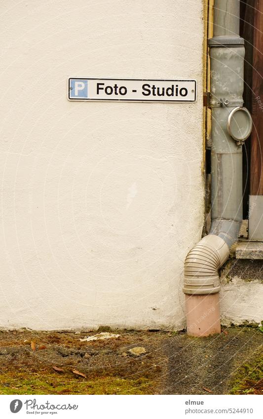 Sign parking photo - studio on a wall next to a rain drain pipe / customer parking lot Customer parking lot Parking lot Photographic studio Waste pipe Downpipe