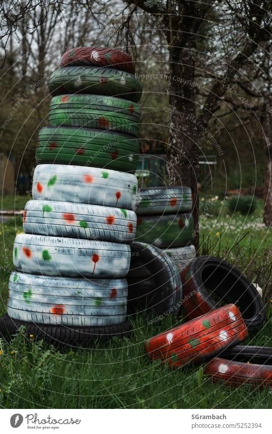 Spring a little different, pile of tires painted, spring colors Tire tire stacks Car tire Recycling Tire tread Exterior shot Environmental pollution Rubber