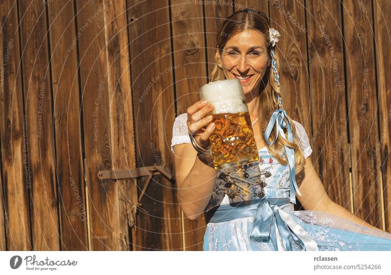 Woman at oktoberfest in traditional Bavarian Tracht holding beer mug in Bavarian or beer garden with copy space woman gold party restaurant drink alcohol