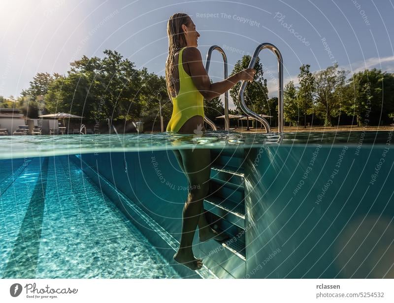 young woman stands by a ladder in a swimming pool, Split above and