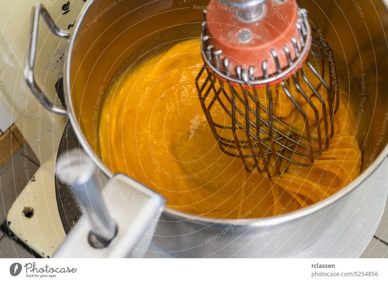 Mixing baking ingredients with egg yolks and sugar in large food mixer for cake or pancakes. Bakery shop concept. speed kitchen milk cooking breakfast bakery