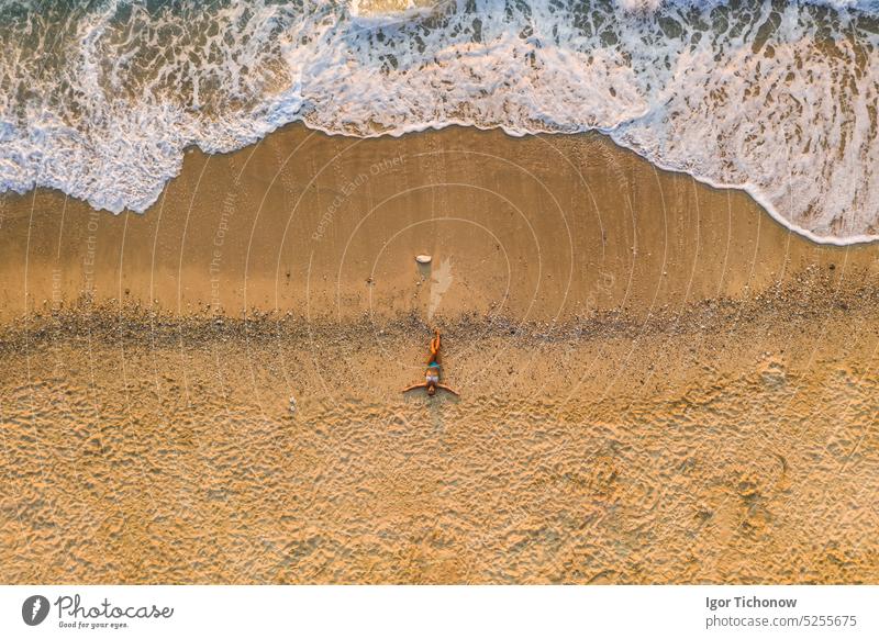 Aerial top down view of woman laying on sandy beach of Milos Beach, Lefkada island, Greece greece turquoise lefkada shore milos nature sea water blue greek